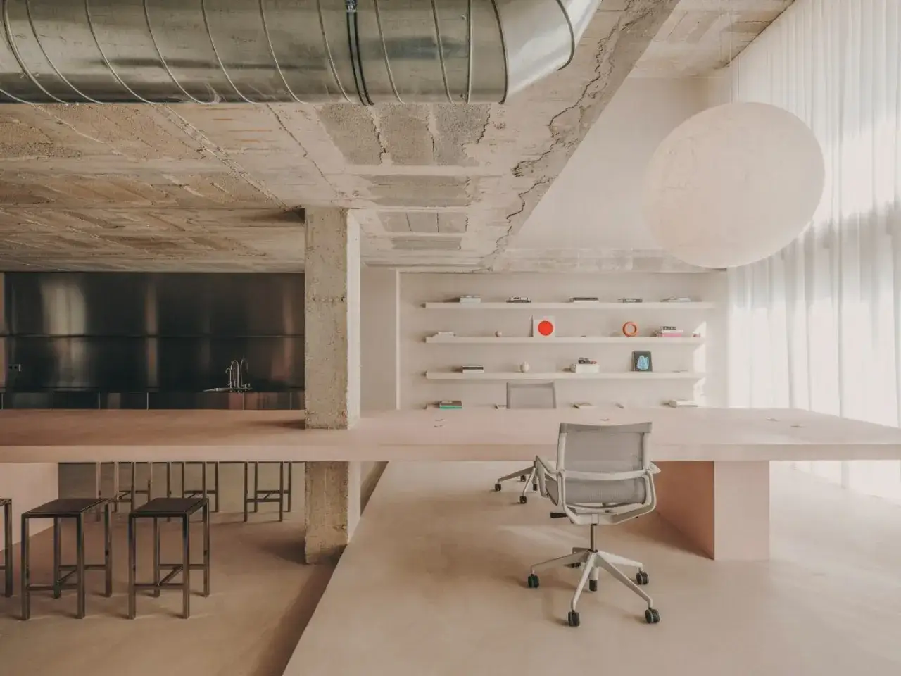 Modernes Büro mit Beton, rosa Tisch und Stühlen, inspiriert von Andres Reisinger.
