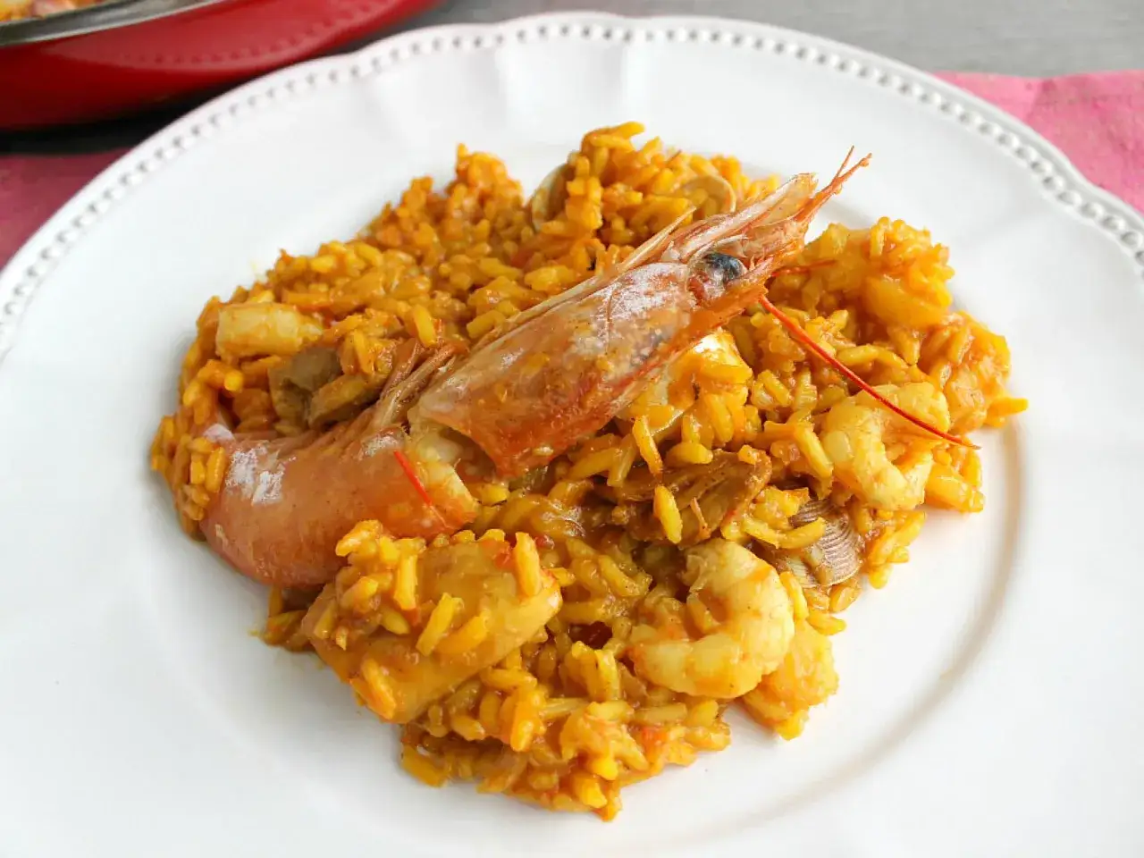 Deliciosa paella con gambas, arroz amarillo y trozos de marisco.