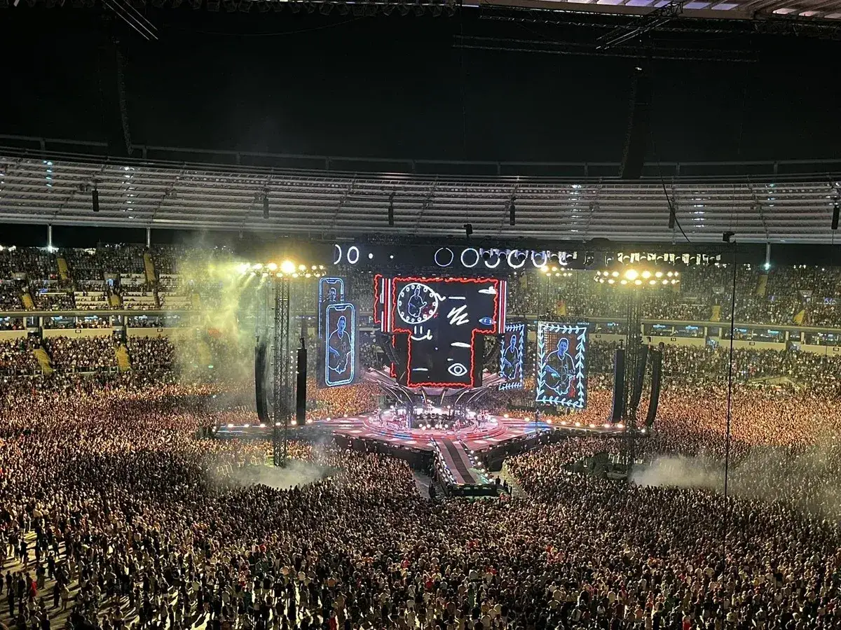 Ogromny tłum na koncercie Metallica 2026. Na scenie wielkie ekrany z grafikami, światła i dym.