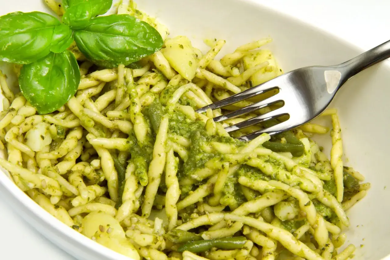 Trofie al pesto, patate e fagiolini: un classico su cosa mangiare a Genova. Fresco e saporito, con basilico profumato.