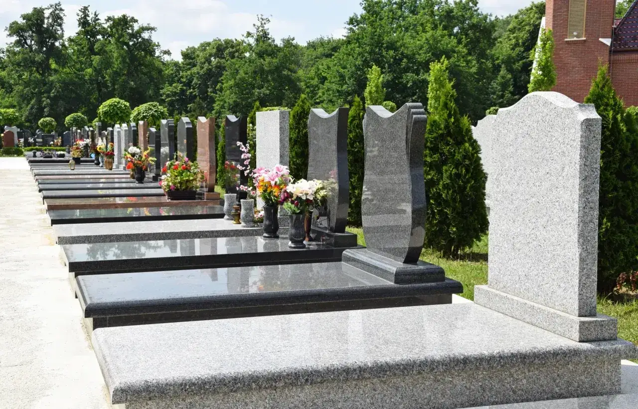 Nowoczesne nagrobki z granitu, co zamiast pomnika na cmentarzu? Rzędy płyt i kwiatów tworzą spokojną przestrzeń pamięci.