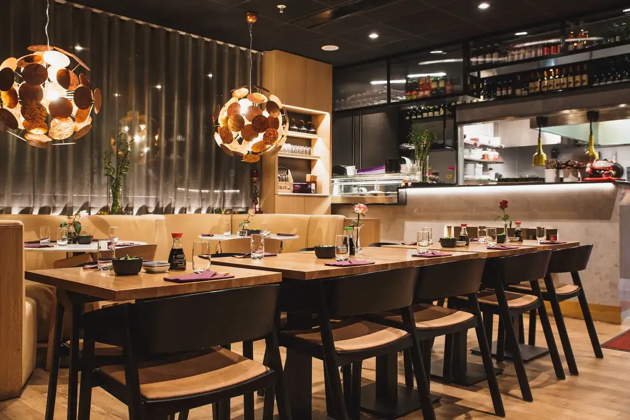 Välkommen till en mysig asiatisk restaurang i Stockholm. Vackert dukade bord med sojasås, glas och servetter väntar på gästerna.