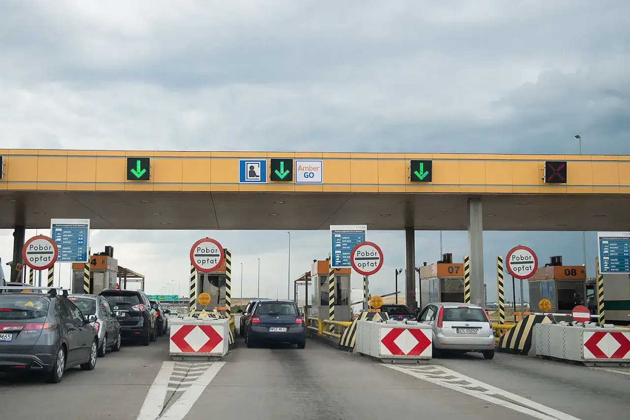 Kolejka samochodów na autostradzie A1 przy bramkach poboru opłat. Widać co najmniej 8 stanowisk.