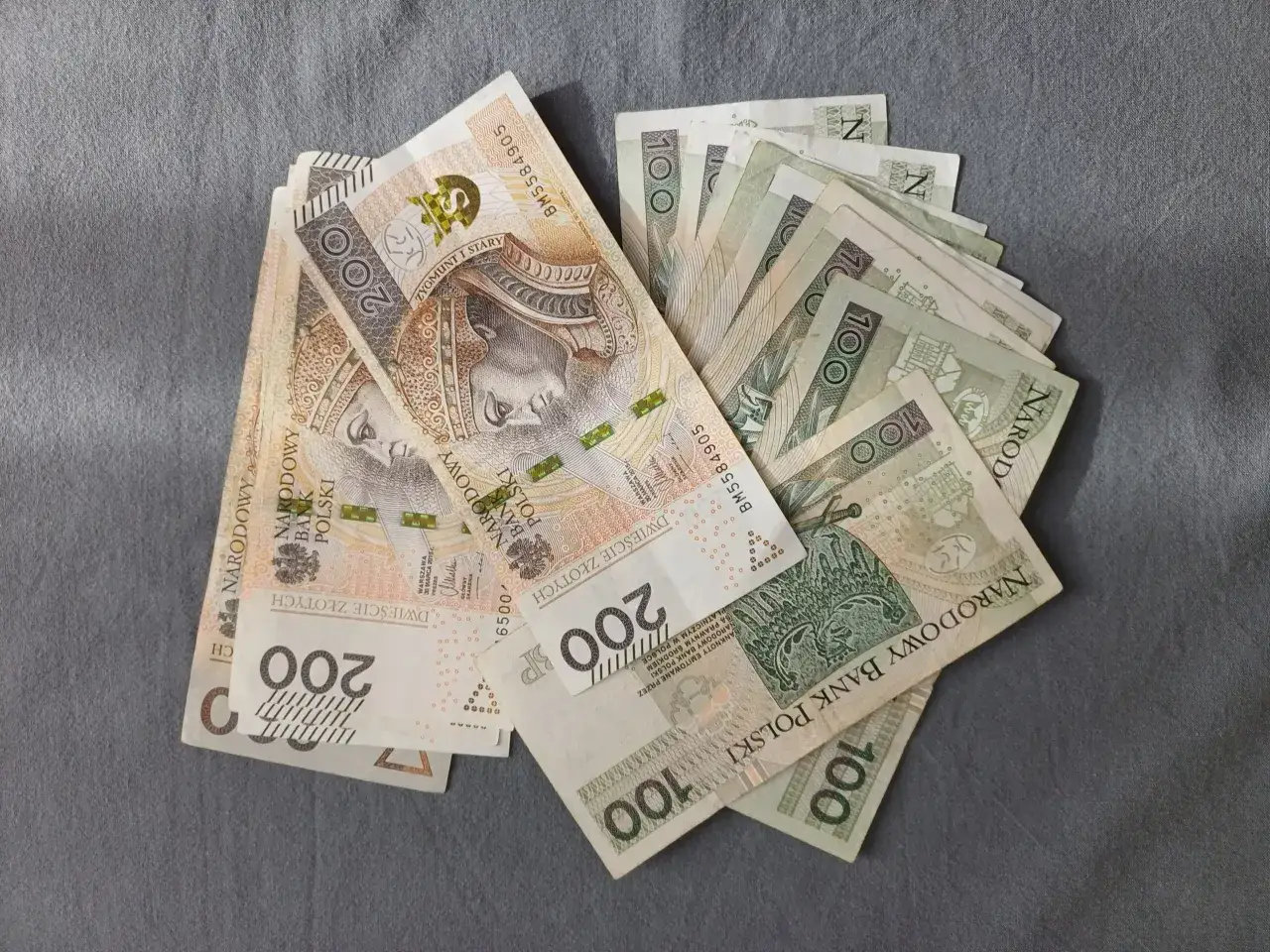 Plik banknotów 100 i 200 zł. Czy można skleić banknoty? Tak, jeśli są uszkodzone, ale trzeba to zrobić ostrożnie.