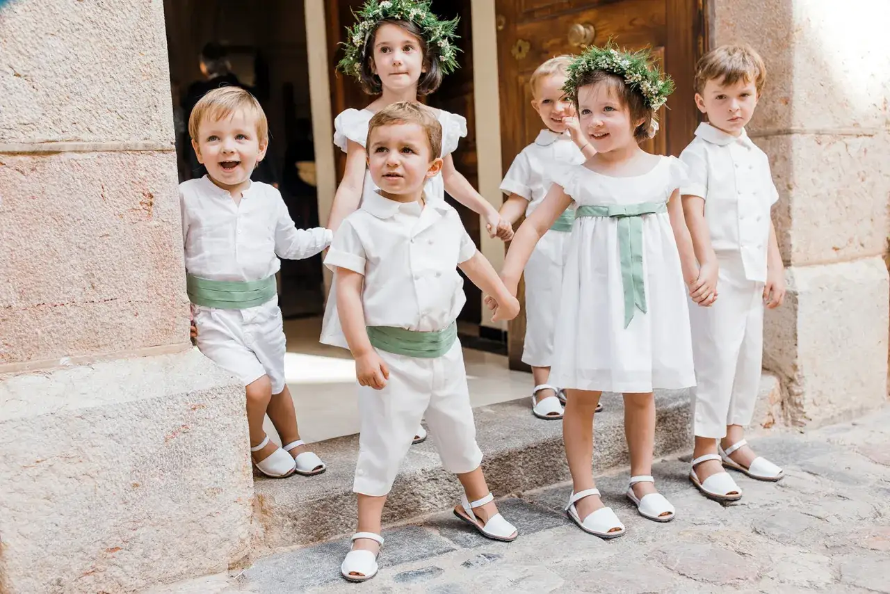 Niños en bodas, vestidos de blanco y verde, esperan con ilusión.