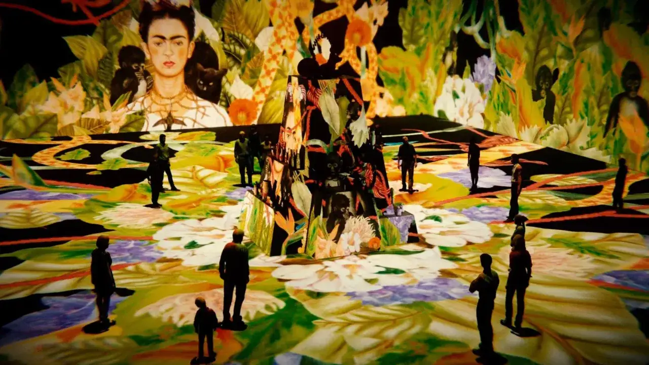 Instalación inmersiva que explora la vida y obra de quien fue Frida Kahlo, con proyecciones de su rostro y arte en un entorno selvático.