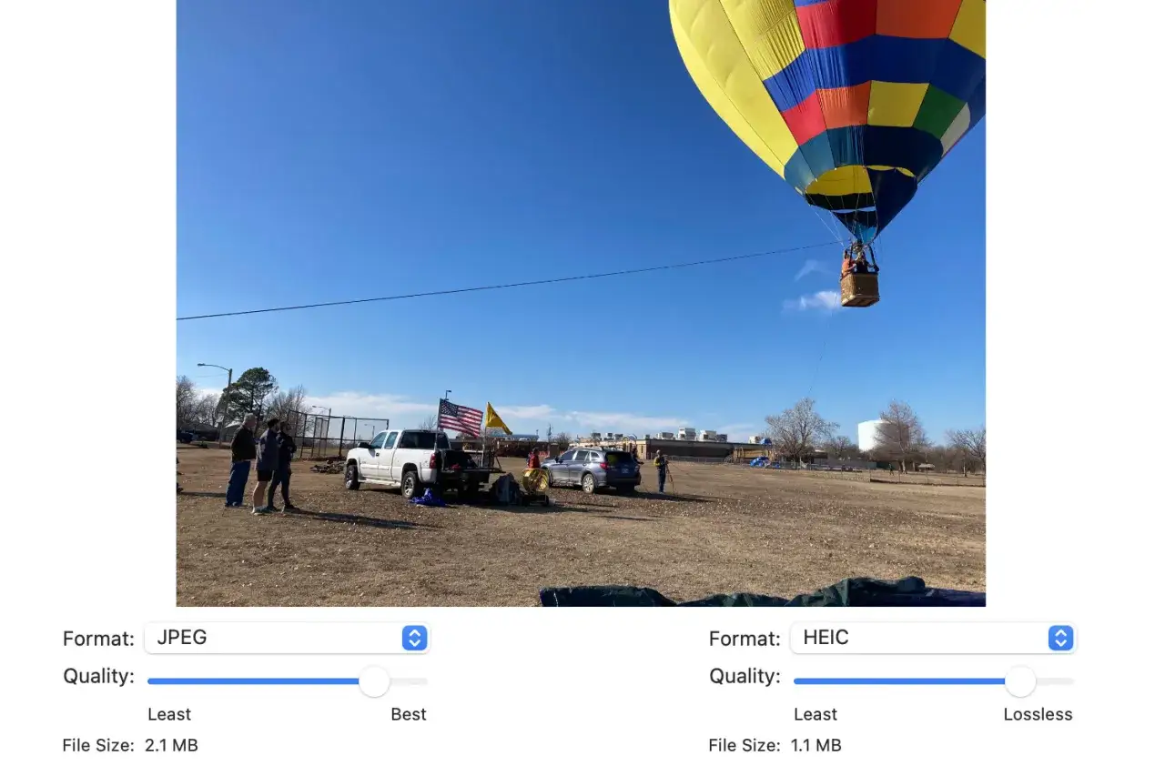 Balon szybuje na błękitnym niebie, obok stoi pickup z flagą USA. Obraz w formacie HEIC, mniejszy niż JPG.