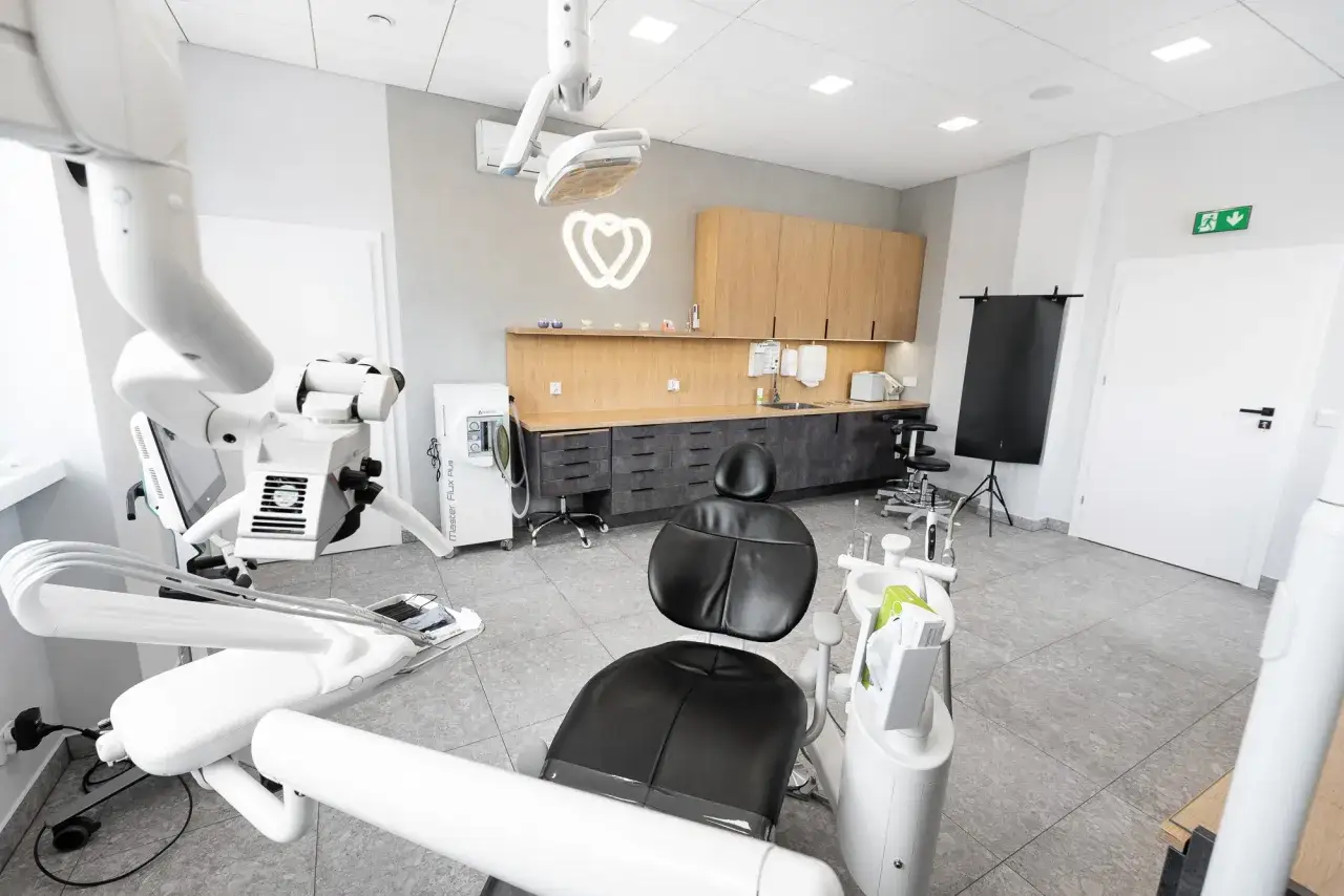 Nowoczesny gabinet stomatologiczny z fotelem dentystycznym i sprzętem medycznym.
