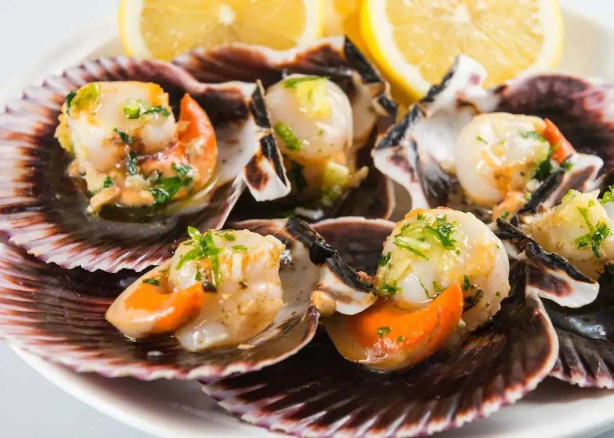 Zamburi&ntilde;as congeladas a la plancha, jugosas y doradas, servidas en sus conchas con lim&oacute;n y perejil. &iexcl;Una delicia f&aacute;cil de preparar!