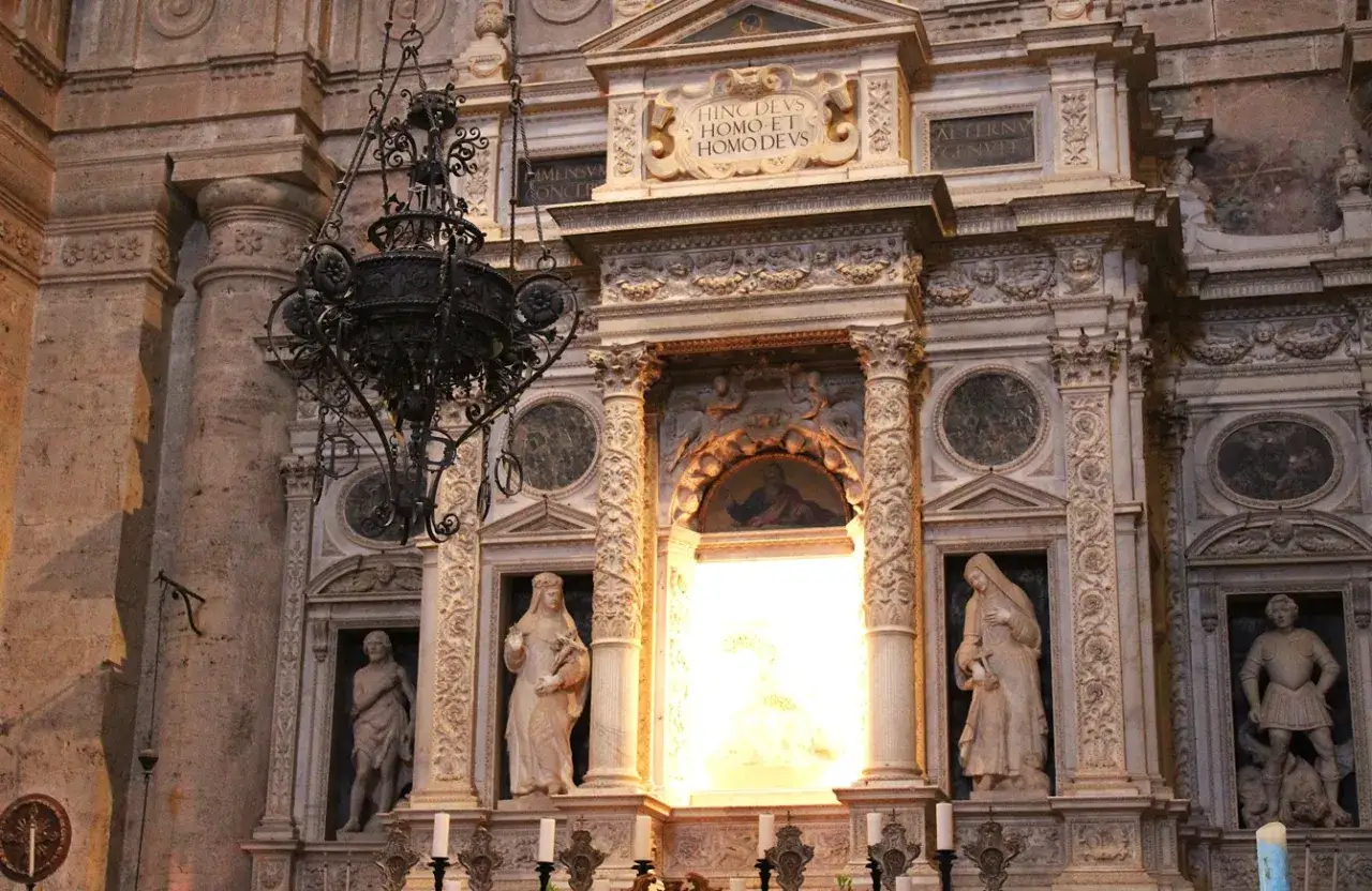 Interno del tempio di San Biagio: statue, affreschi e un lampadario in ferro battuto creano un'atmosfera solenne.
