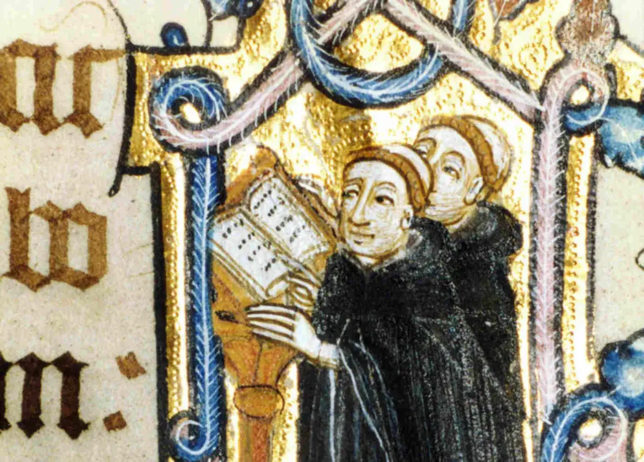 Two monks in Benedictine habits study a richly illuminated manuscript. The title of the work is obscured by the ornate border.