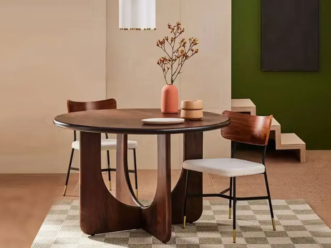 A modern round dining table with a sculptural base, showcasing one of the many stylish types of kitchen tables.