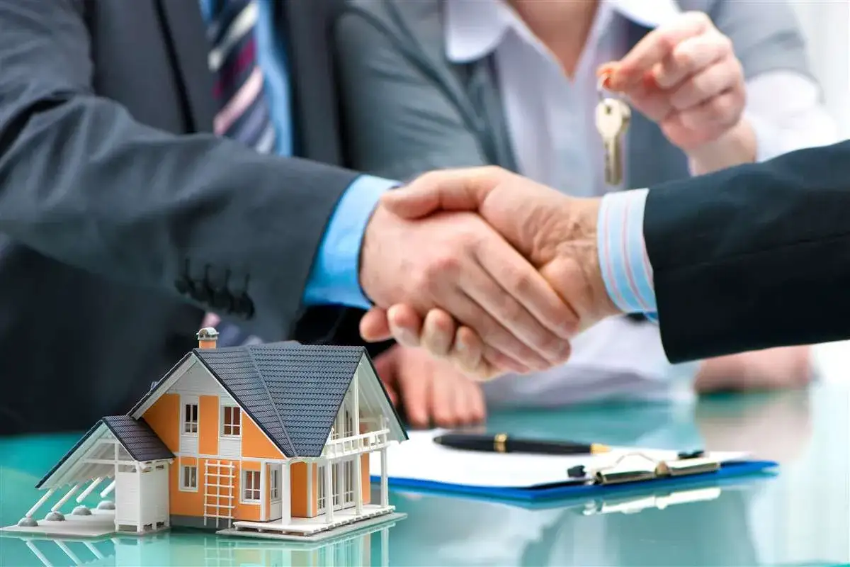 Affare concluso: stretta di mano, chiavi e modello di casa. È il momento giusto per pensare che conviene comprare casa.