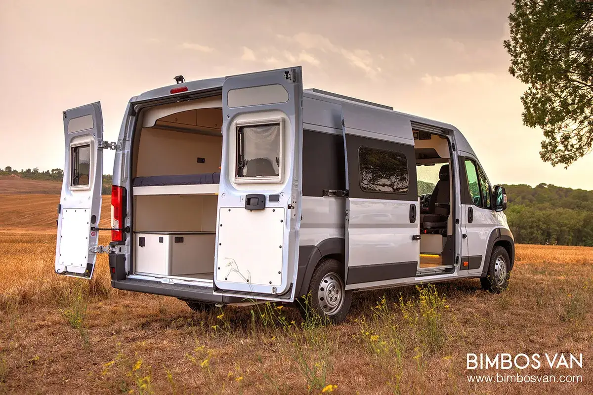 Furgoneta camper abierta, mostrando cama y almacenamiento. Ideal para quienes buscan las mejores furgonetas camper calidad precio.