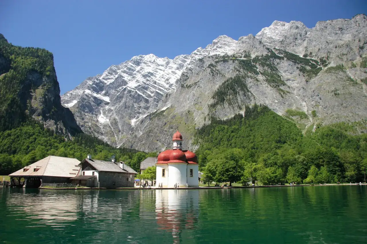 Idyllische Kirche am Königssee. Hier kann man in Bayern wandern, Boot fahren und die Natur genießen.