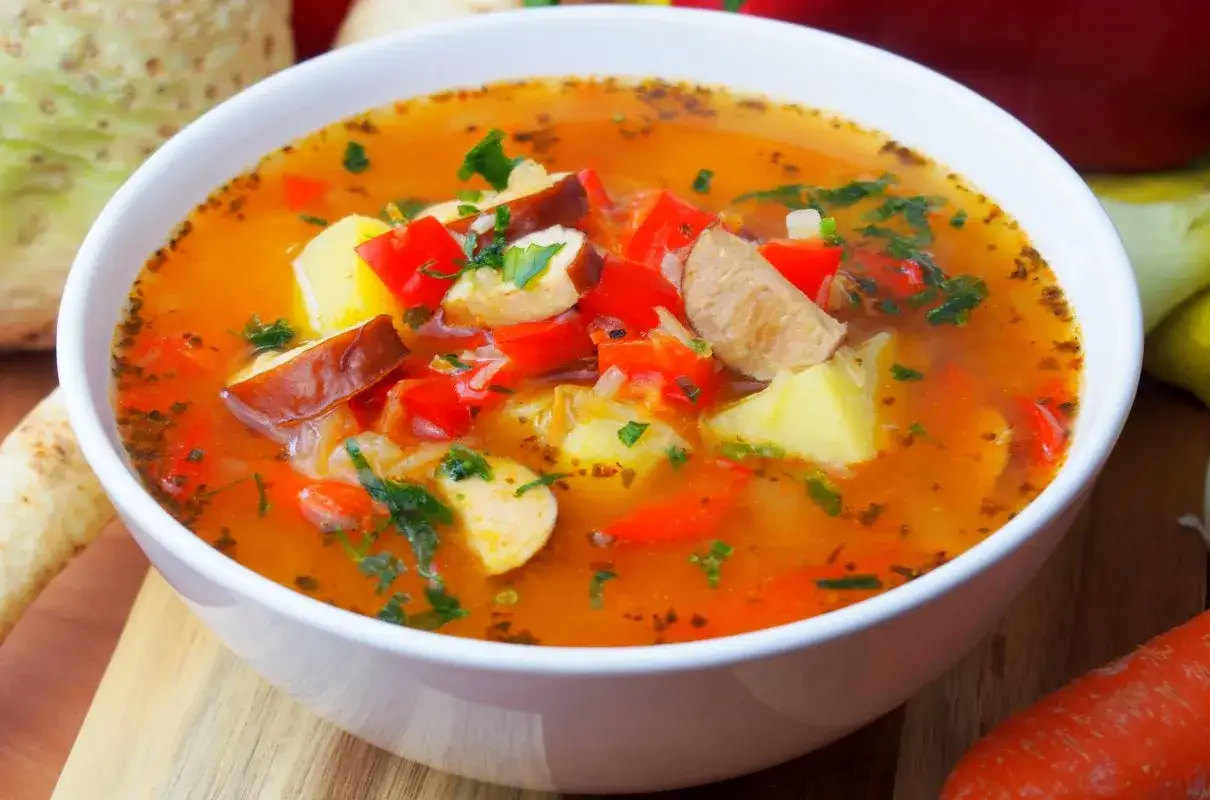 Aksamitna zupa cygańska z mięsem, ziemniakami i papryką, posypana natką pietruszki. Aromatyczna i sycąca.