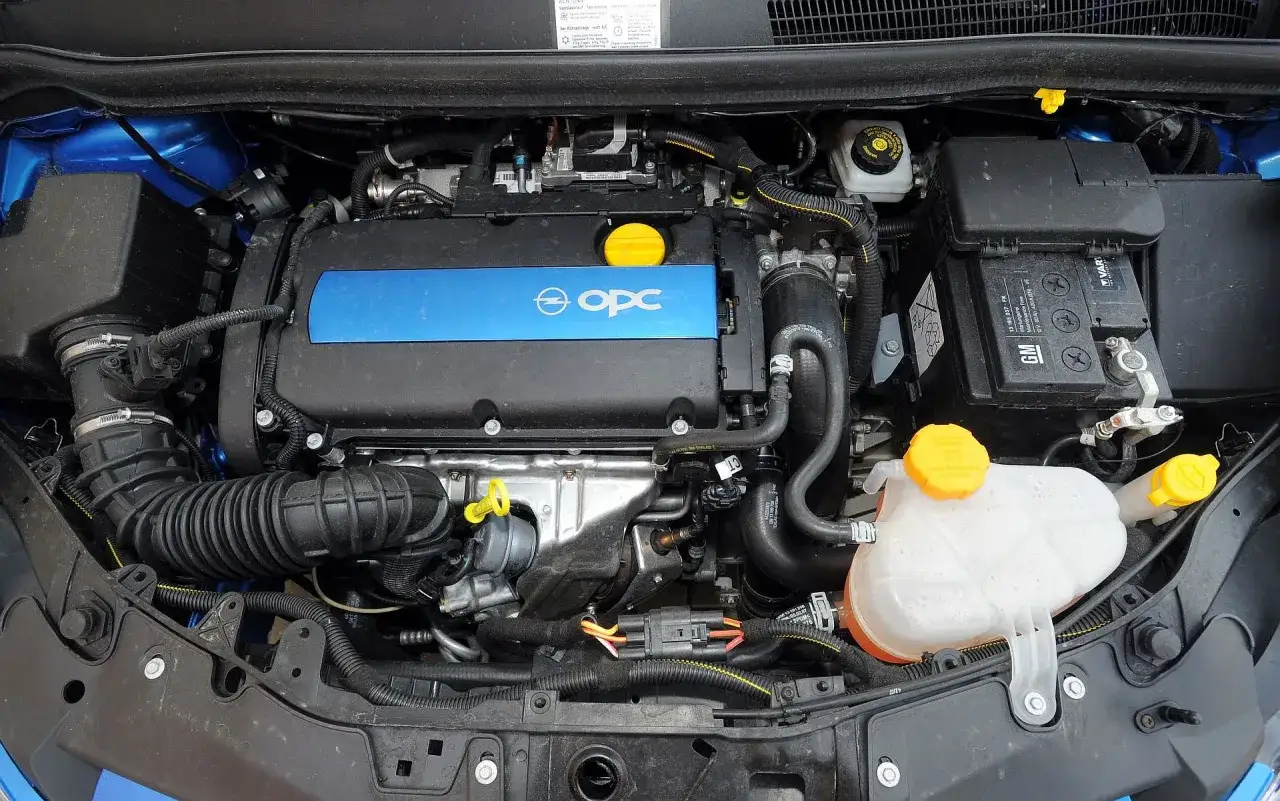 Silnik Opel Corsa D 1.2 benzyna, widok komory silnika z niebieską nakładką OPC.