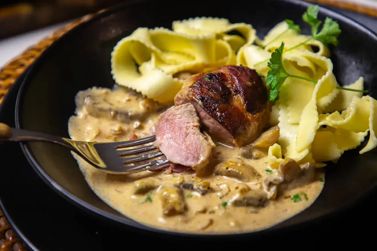 Ein saftiges Schweinefilet, umhüllt von einer cremigen Pilzsoße, serviert mit Bandnudeln. Perfekt für köstliche Schweinefilet Rezepte.