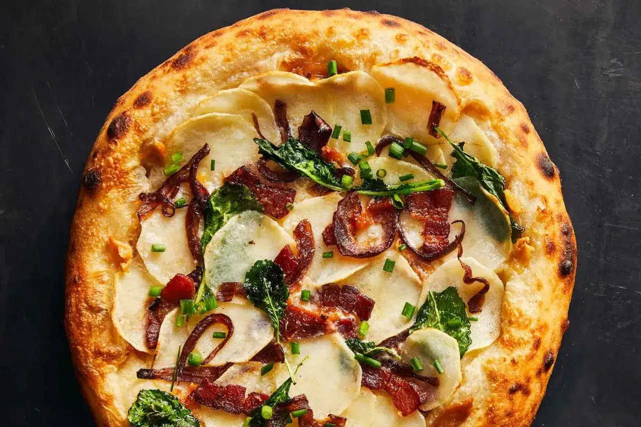 Pizza bianca z ziemniakami, boczkiem i szczypiorkiem. Chrupiące ciasto, kremowe ziemniaki i słony boczek tworzą idealne połączenie.