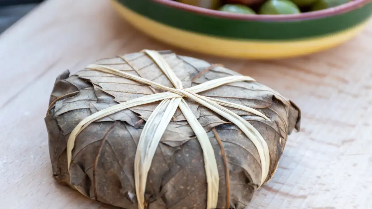 Un mets envelopp&eacute; de feuilles s&eacute;ch&eacute;es, li&eacute; par des brins v&eacute;g&eacute;taux. Une sp&eacute;cialit&eacute; des Hautes-Alpes, peut-&ecirc;tre un p&acirc;t&eacute; de campagne.