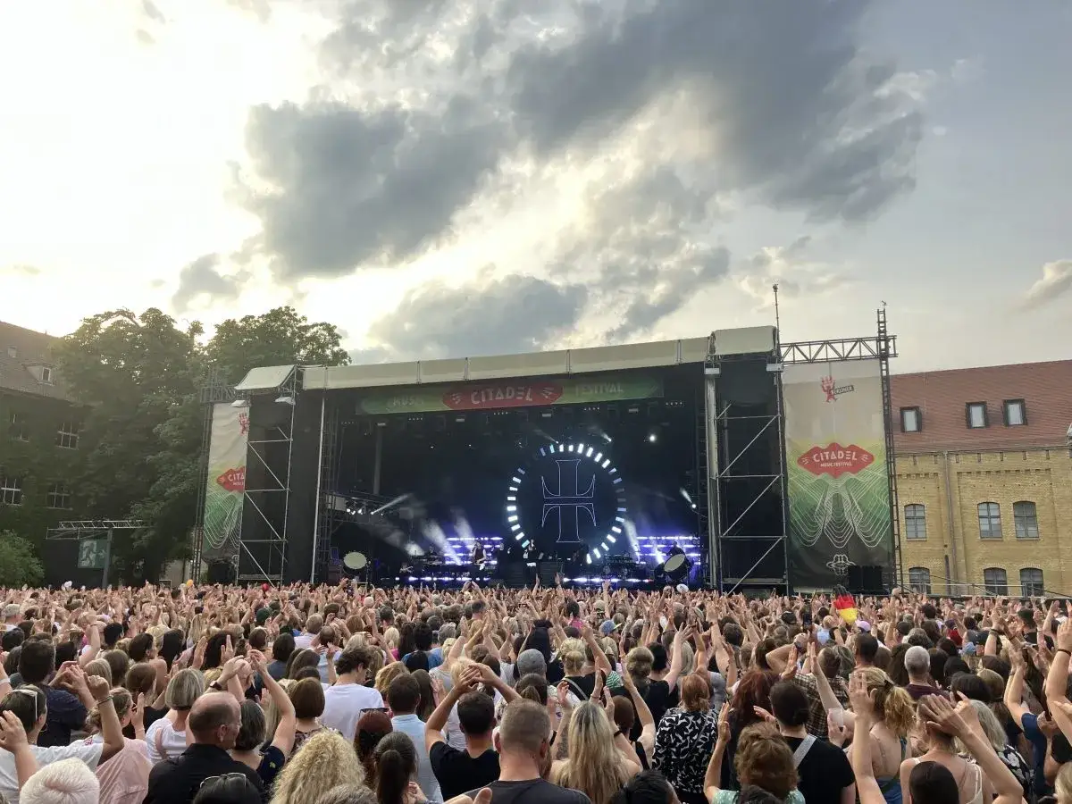 Ein riesiges Publikum feiert beim Citadel Music Festival in Berlin. Die B&uuml;hne ist beleuchtet, die Menge jubelt.