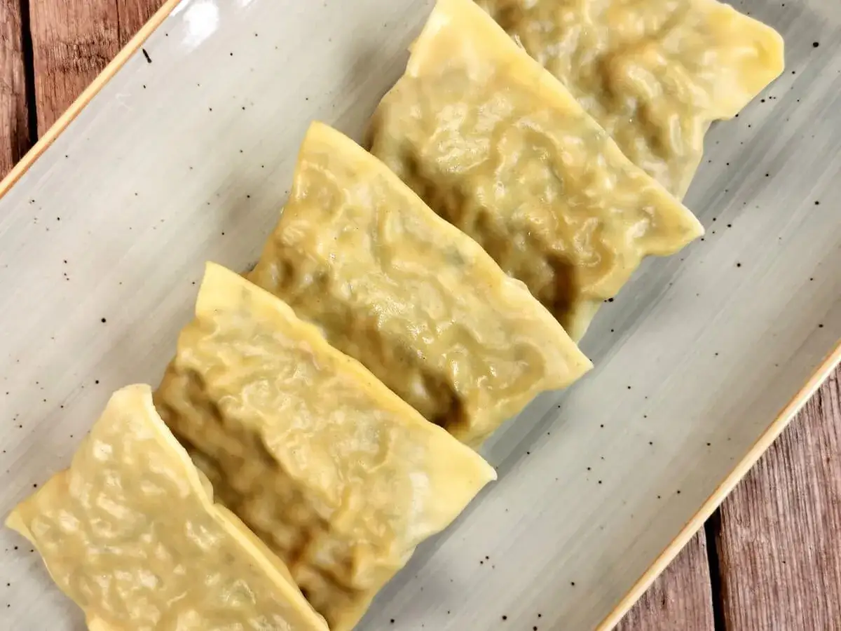 F&uuml;nf dampfende Maultaschen auf einem Teller, bereit f&uuml;r ein k&ouml;stliches Maultaschen Rezept.