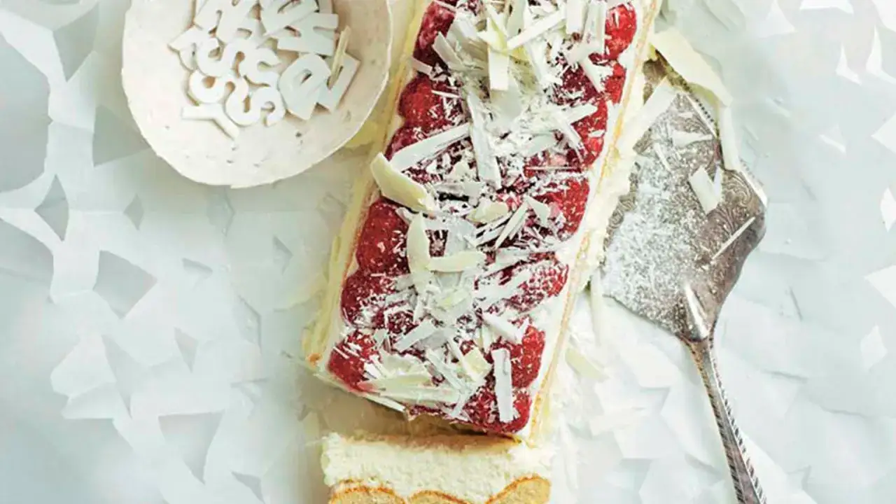 Deliciosa tarta de chocolate blanco con frambuesas y virutas de chocolate. Un postre elegante y fresco.