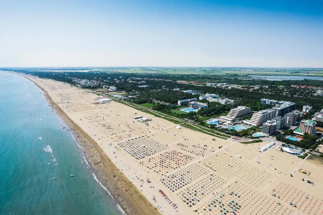 Vue a&eacute;rienne de la plage de Bibione, Italie, avec des rang&eacute;es de parasols et de chaises longues, des h&ocirc;tels et la mer Adriatique.