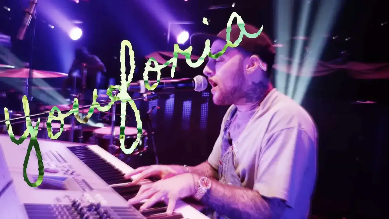 Mac Miller w blasku świateł, grając na klawiszach i śpiewając, wywołuje uczucie **euforii**.