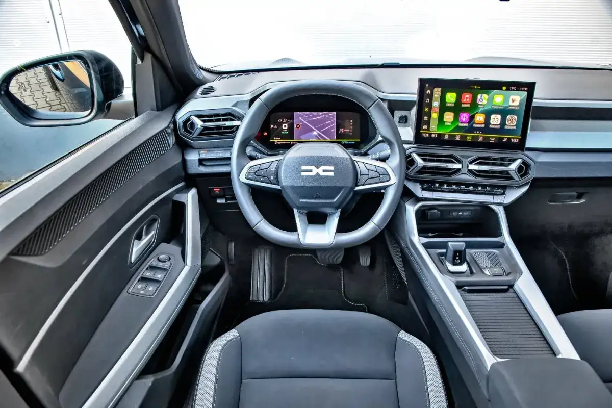 Wnętrze Dacia hybrid z nowoczesnym ekranem multimedialnym i cyfrowymi zegarami.