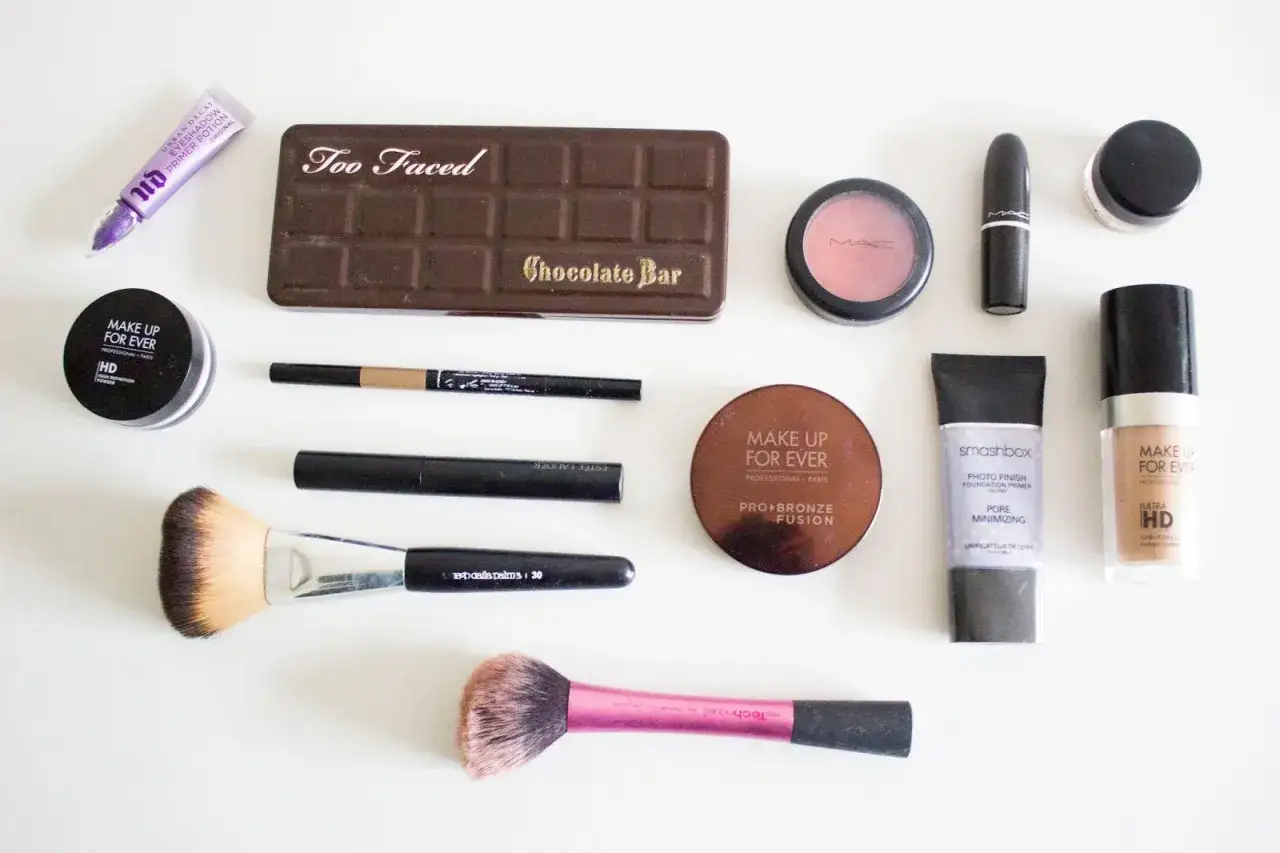 Collection de maquillage pour un prix abordable : fond de teint, poudre, blush, pinceaux, crayon, mascara, et palette Too Faced Chocolate Bar.