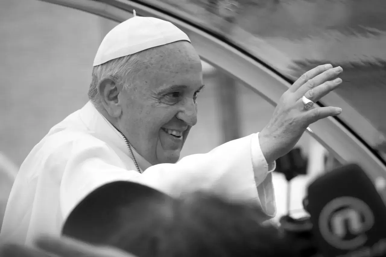 Uśmiechnięty papież Franciszek pozdrawia tłum. Jego życiorys to historia oddania i wiary.