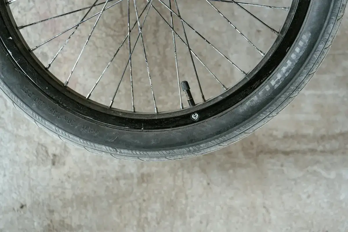 Zużyta opona rowerowa leży na betonie. Zastanawiasz się, gdzie wyrzucić opony rowerowe? Sprawdź lokalne punkty zbi&oacute;rki odpad&oacute;w.