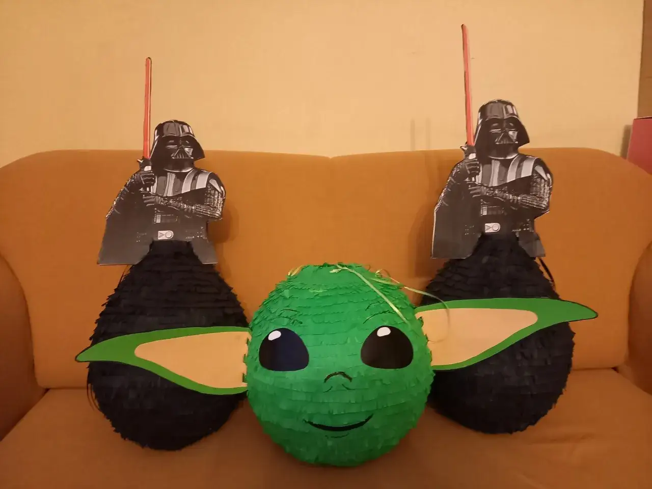 Dwie pinaty w kształcie Dartha Vadera i jedna w kształcie Grogu, czyli Baby Yody, czekają na rozbicie. To idealne dekoracje na imprezę w stylu pinata Star Wars!