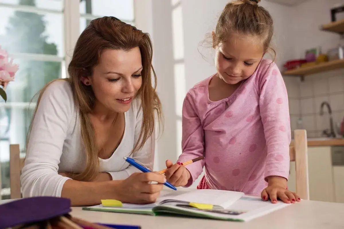 Madre ayuda a su hija con la tarea, apoyando en la superaci&oacute;n de la dislexia en ni&ntilde;os.