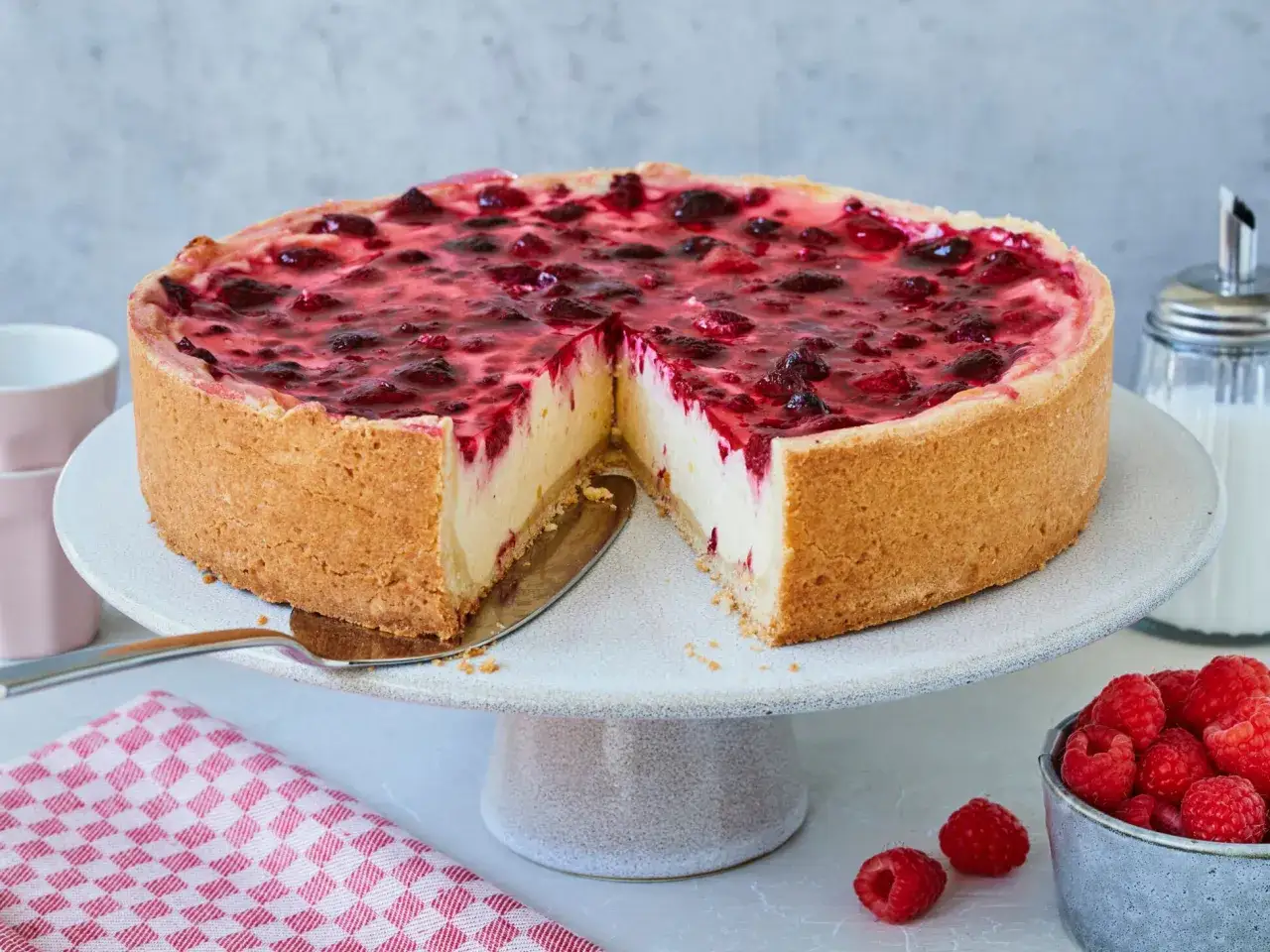 Ein köstlicher Himbeer Schmand Kuchen mit einem knusprigen Boden und saftiger Füllung, belegt mit frischen Himbeeren.