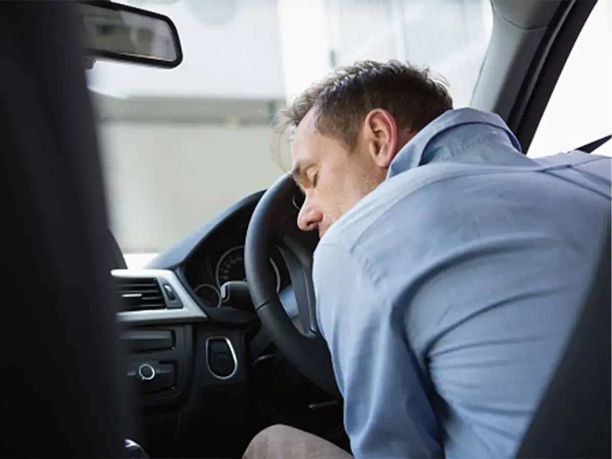 Hombre durmiendo al volante. Para evitar la fatiga en la conducción conviene descansar.