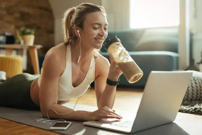 osoba pije shake białkowy przed treningiem