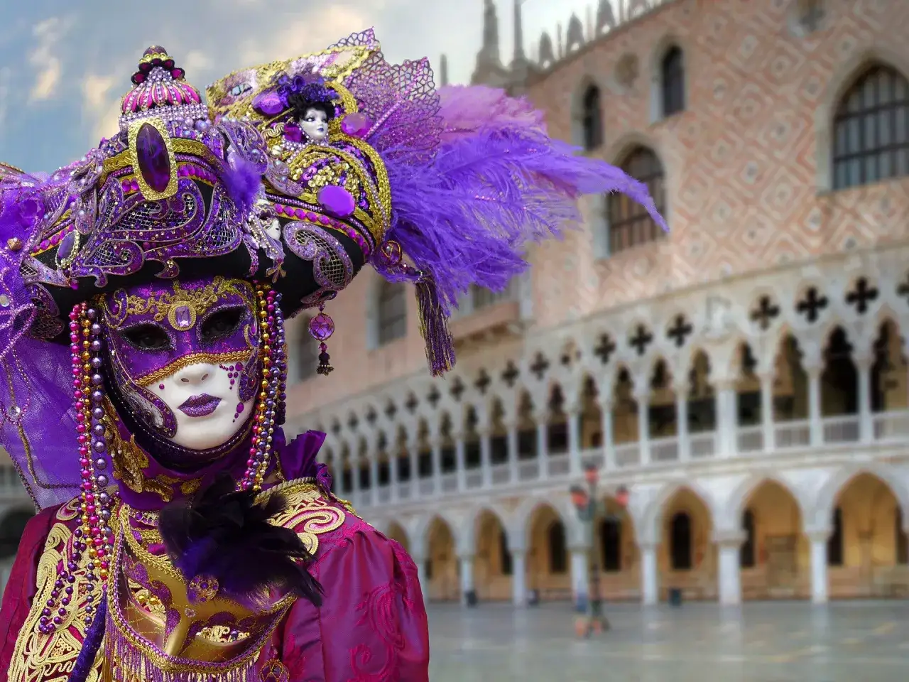 Un'elaborata maschera di Carnevale viola e oro, con piume e perline, in Piazza San Marco, quando si festeggia Carnevale.