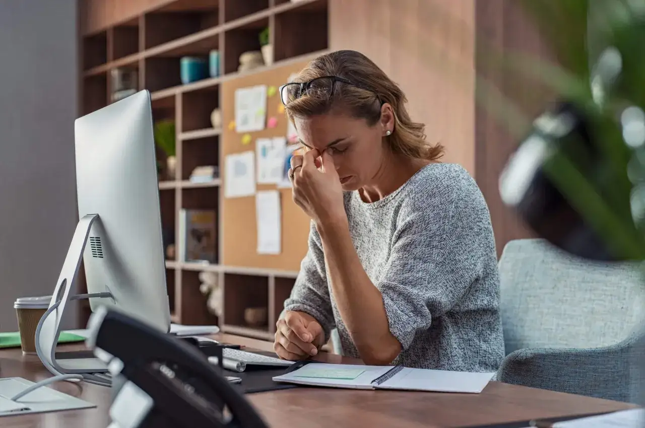 Femme fatiguée au bureau, se frottant les yeux pour reposer les yeux. Elle a besoin d'une pause.