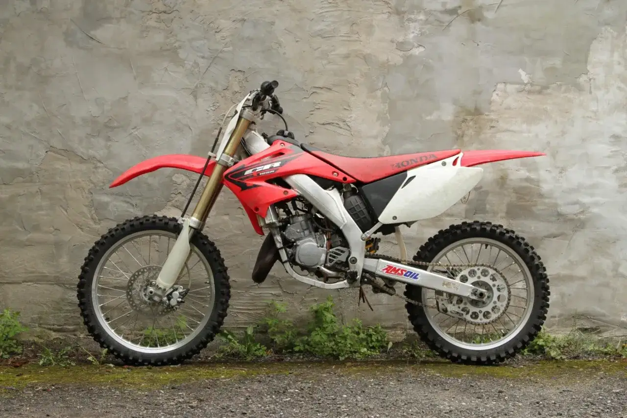 Czerwony motocykl crossowy Honda CR 125, gotowy do akcji. Zastanawiasz się, honda cr 125 ile koni ma pod maską?
