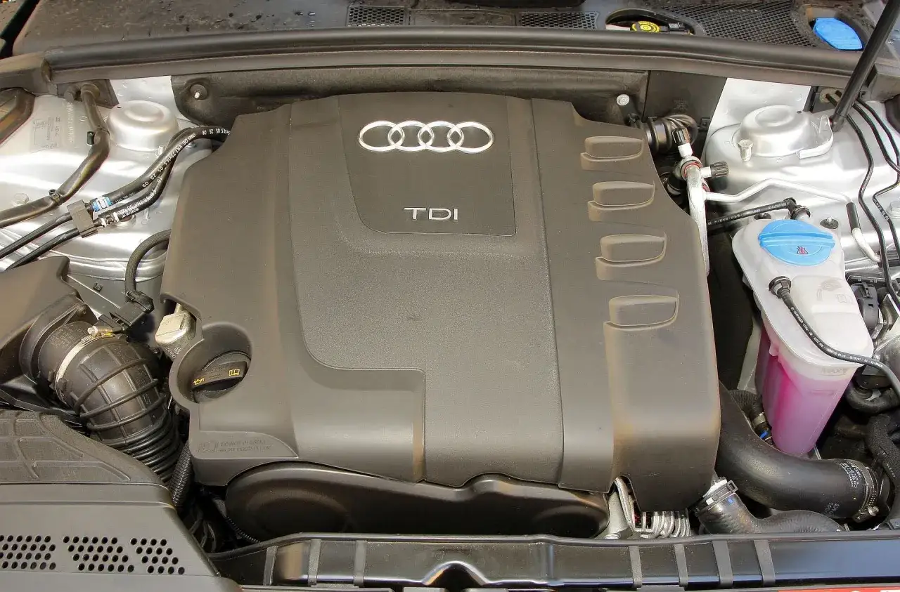Silnik TDI Audi A5, znany z niezawodności. Pod czarną osłoną z logo Audi kryje się serce tego modelu, cenione za trwałość.