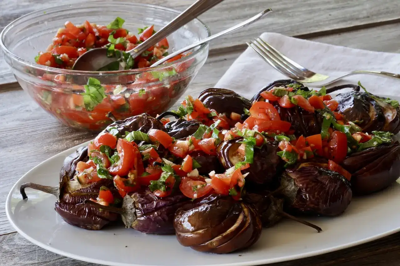 Ugnsbakad aubergine fylld med tomater och örter. En härlig aubergine i ugn som ser utsökt ut.
