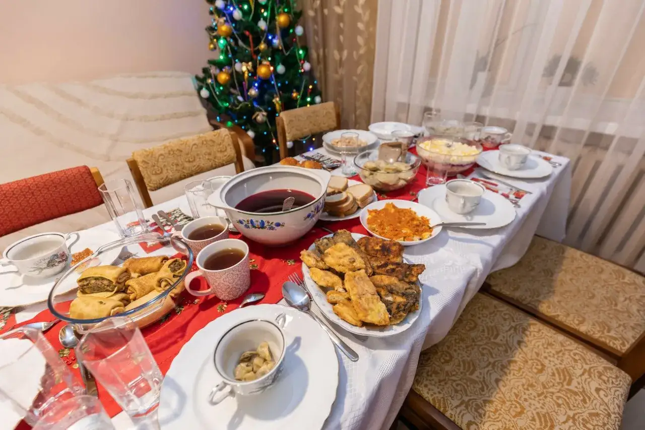 Wigilijny stół ugina się pod ciężarem potraw: barszcz, pierogi, ryby, kapusta. To lista 12 potraw wigilijnych, gotowa do świętowania.