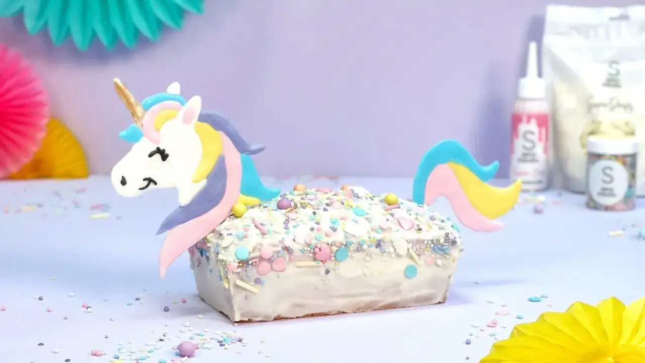 Ein magischer einhorn kuchen, verziert mit bunten Streuseln und einem süßen Einhorn-Topper, bereit für eine zauberhafte Feier.