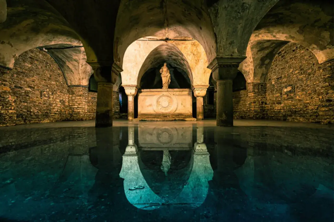 Sotterranei di Venezia misteriosa, con statue e riflessi sull'acqua.