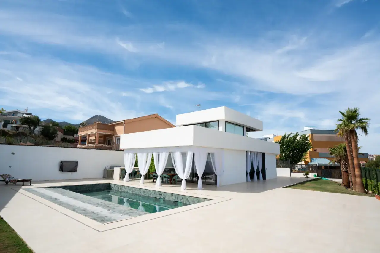Modern white house with pool, showing ideal pasos a seguir para construir una casa.