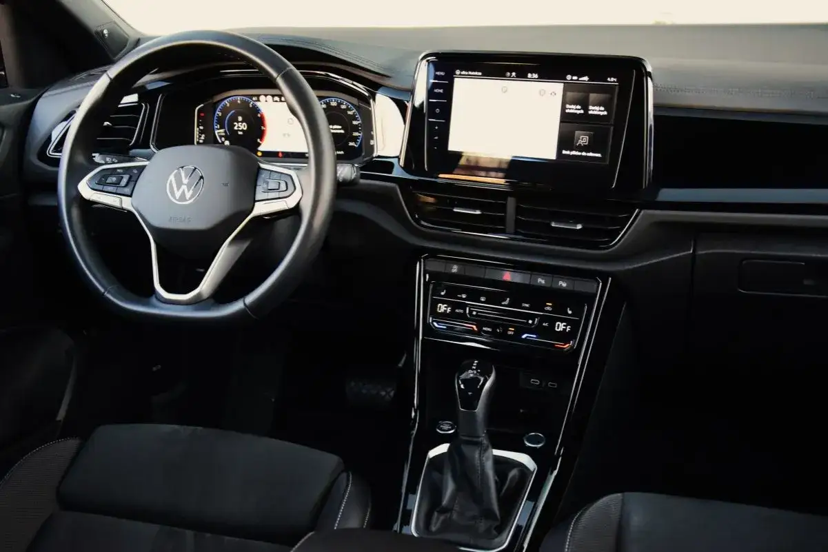 Wnętrze Volkswagena T-Roc 2025: kierownica, ekran multimediów i panel klimatyzacji.
