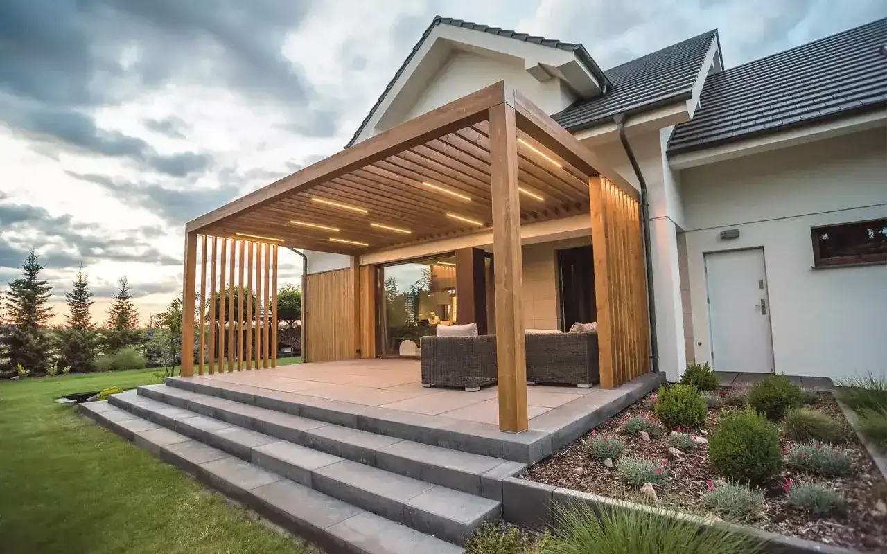 Nowoczesna pergola z oświetleniem LED, idealna na taras. Wygodne meble wypoczynkowe zapraszają do relaksu.