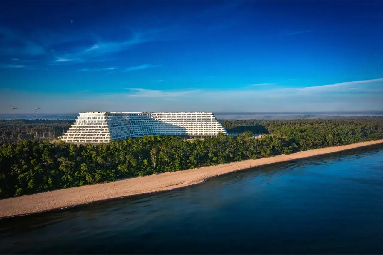 Majestatyczny hotel Gołębiewski w Mielnie, otoczony lasem i plażą, z widokiem na spokojne morze.